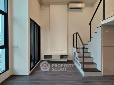 Modern duplex living room with sleek staircase and large windows