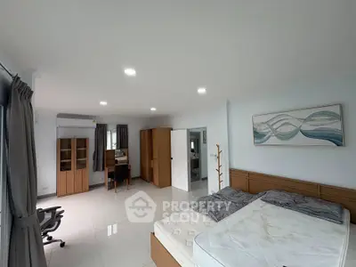 Spacious bedroom with modern furniture and natural light, perfect for comfort and relaxation.