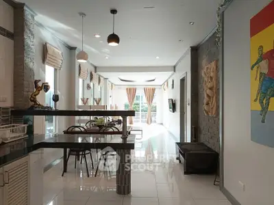 Spacious modern living room with dining area, stylish decor, and large windows for natural light.