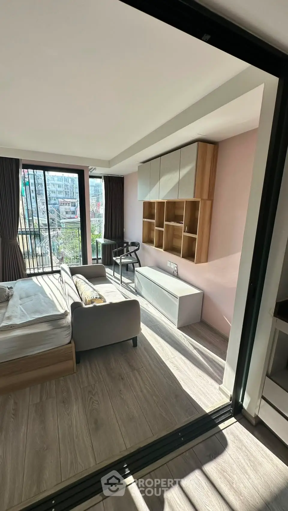 Modern living room with stylish furniture and large windows offering natural light and city views.