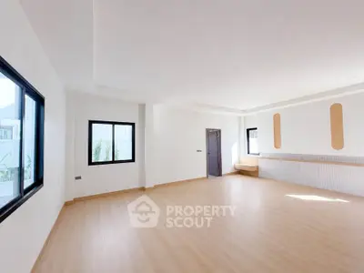 Spacious modern living room with large windows and minimalist design.