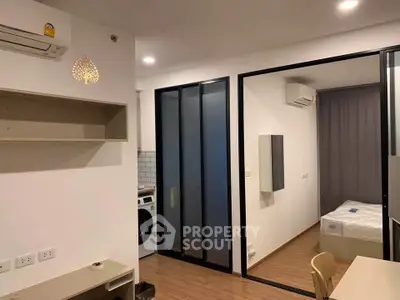 Modern studio apartment with sliding glass doors and in-unit washer, featuring sleek design and efficient layout.