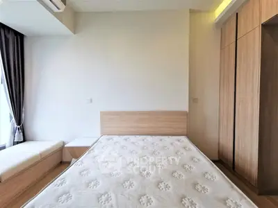 Modern bedroom with minimalist design, featuring a wooden bed frame and built-in wardrobe.
