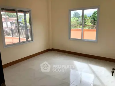 Spacious empty room with large windows and tiled flooring, perfect for customization.