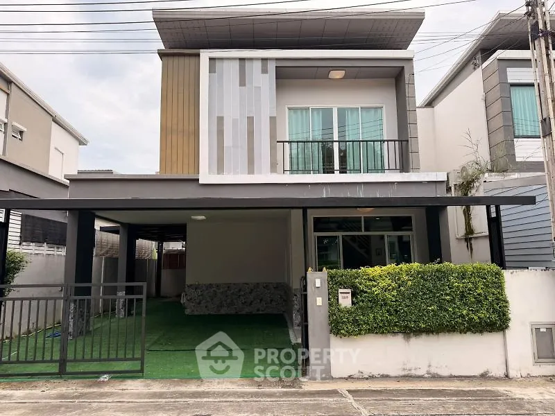 Modern two-story house with unique facade and spacious carport in a suburban neighborhood.