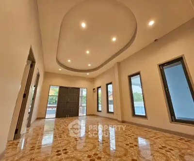 Spacious living room with elegant ceiling design and large windows.