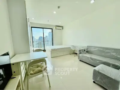 Modern studio apartment with city view, featuring sleek furniture and natural light.