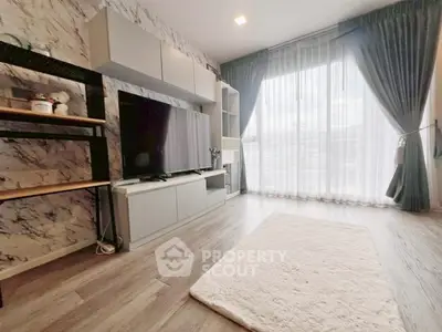 Modern living room with large TV, stylish shelving, and floor-to-ceiling windows with elegant curtains.