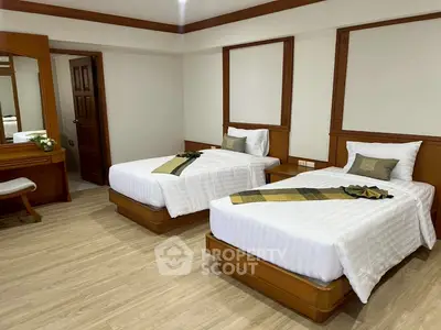 Spacious twin bedroom with elegant wooden furniture and modern decor