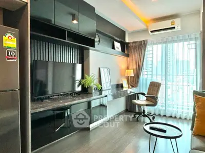 Modern living room with sleek black furniture and city view, featuring a stylish workspace and large window.