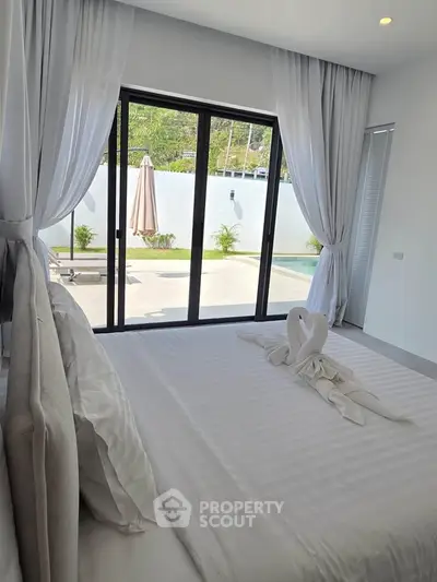 Luxurious bedroom with pool view and elegant decor in modern home
