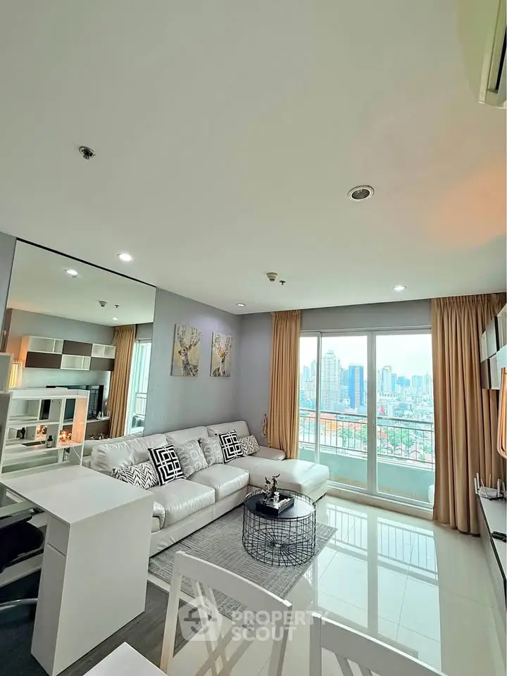 Modern living room with city view, stylish decor, and ample natural light in high-rise apartment.