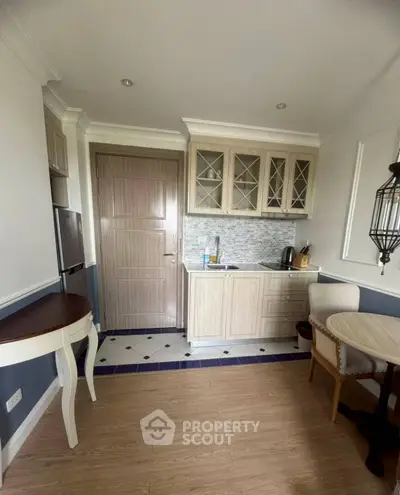 Charming compact kitchen with elegant cabinetry and cozy dining area, perfect for small apartments.