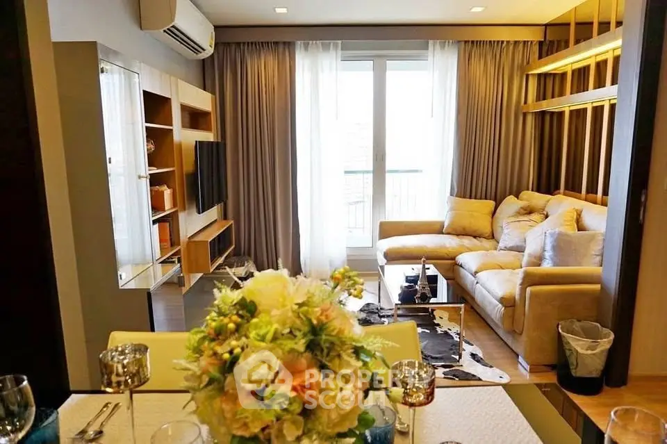 Stylish living room with cozy sofa, modern decor, and natural light from large windows.