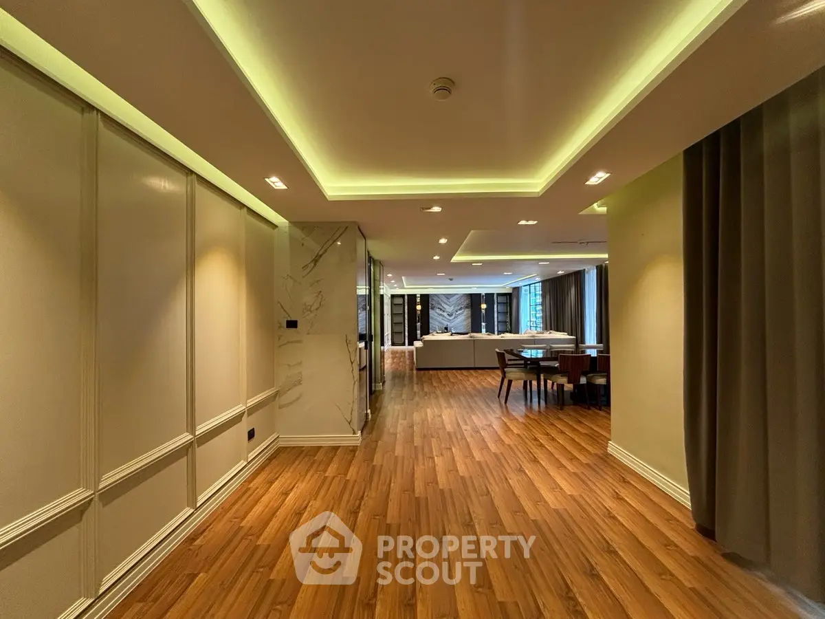 Luxurious open layout living space with elegant wood flooring and modern lighting.