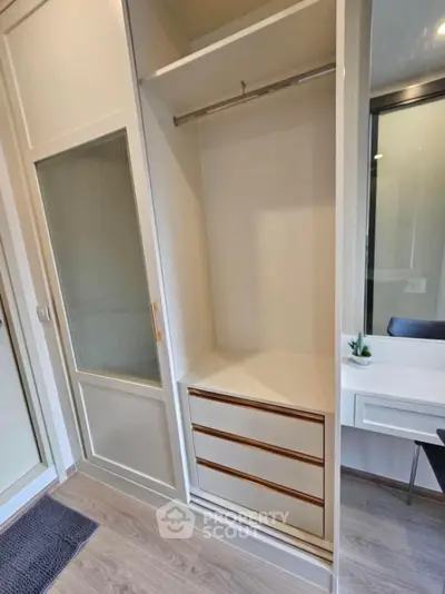 Spacious modern wardrobe with sliding doors and built-in drawers in stylish apartment.