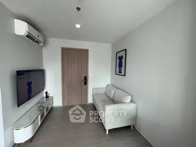 Modern living room with sleek furniture and wall-mounted TV in a stylish apartment.