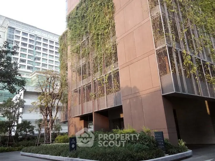 Modern building exterior with lush vertical garden and urban surroundings.