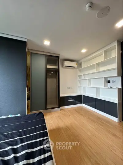 Modern bedroom with built-in shelves and air conditioning