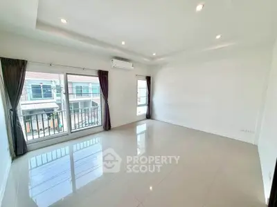 Spacious unfurnished living room with large windows and modern lighting in a bright apartment.