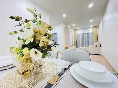 Elegant living room with modern decor and floral centerpiece, showcasing a bright and inviting atmosphere.