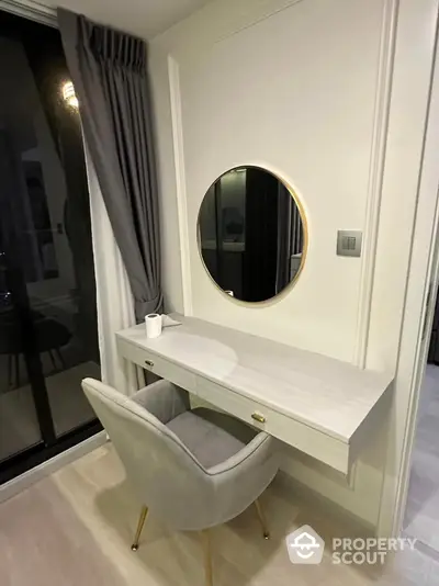 Elegant bedroom corner with modern vanity and plush chair near window