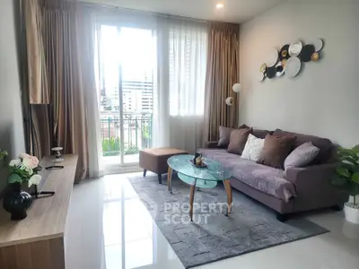 Modern living room with stylish decor and balcony view in urban apartment.