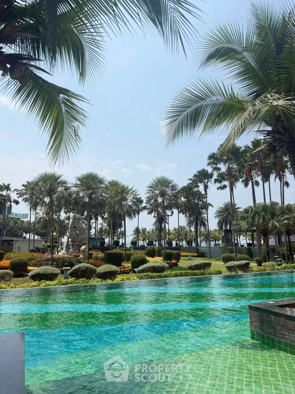 Luxurious tropical resort pool with lush palm trees and vibrant landscaping