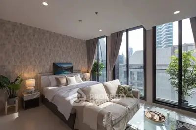 Luxurious bedroom with floor-to-ceiling windows and city view, featuring elegant decor and cozy seating area.