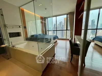 Luxurious bedroom with glass-enclosed bathtub and stunning city view