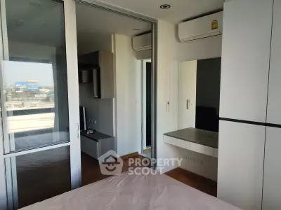 Modern bedroom with large window and air conditioning in urban apartment