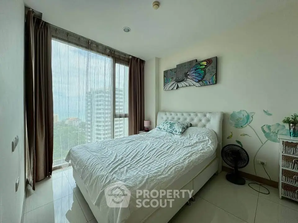 Bright bedroom with large window and modern decor in high-rise apartment