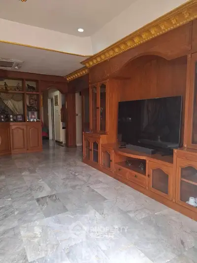 Spacious living room with elegant wooden cabinetry and marble flooring