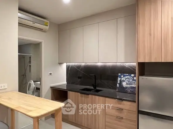 Modern kitchen with sleek cabinetry and integrated appliances in a stylish apartment.
