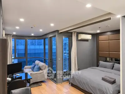 Modern studio apartment with large windows and city view, featuring cozy living area and stylish bedroom.