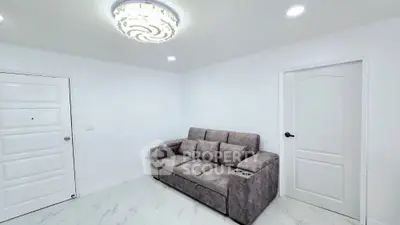 Modern living room with elegant chandelier and plush grey sofa