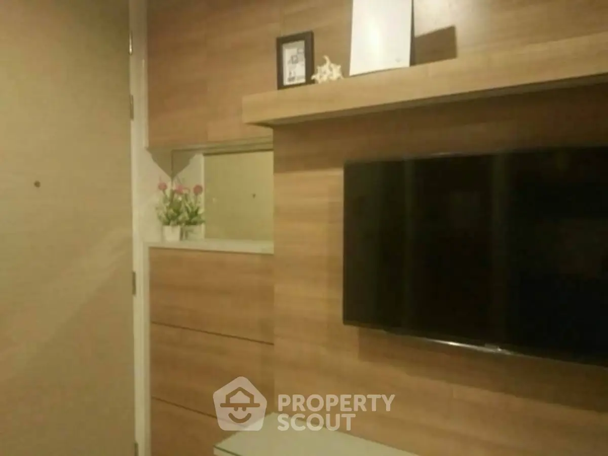 Modern living room with wall-mounted TV and stylish wooden paneling.