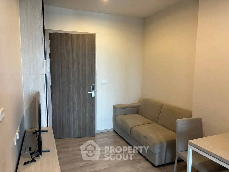 Cozy living room with modern sofa and flat-screen TV, perfect for relaxation.