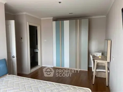 Spacious bedroom with modern wardrobe and cozy workspace in a stylish apartment.