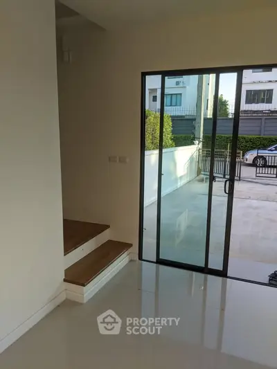 Modern home entrance with sliding glass door and polished floors