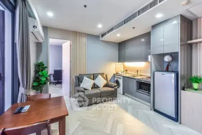 Modern living room with sleek kitchen, cozy seating, and stylish decor in a contemporary apartment.