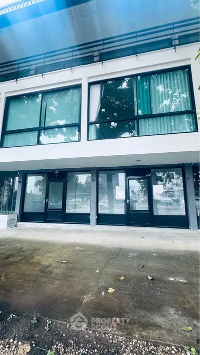 Modern building exterior with large glass windows and sleek design, perfect for commercial or residential use.