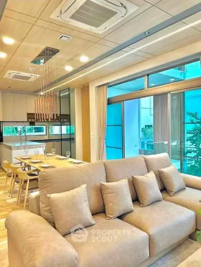 Luxurious open-plan living room with modern kitchen and large windows offering stunning views.