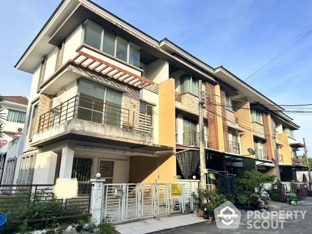 Modern multi-story residential building with large windows and balconies in urban setting