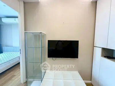Modern living room with wall-mounted TV and glass display cabinet