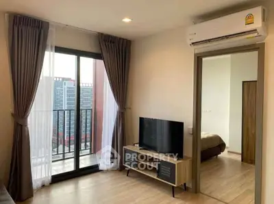 Modern living room with balcony access and sleek TV setup in a stylish apartment.