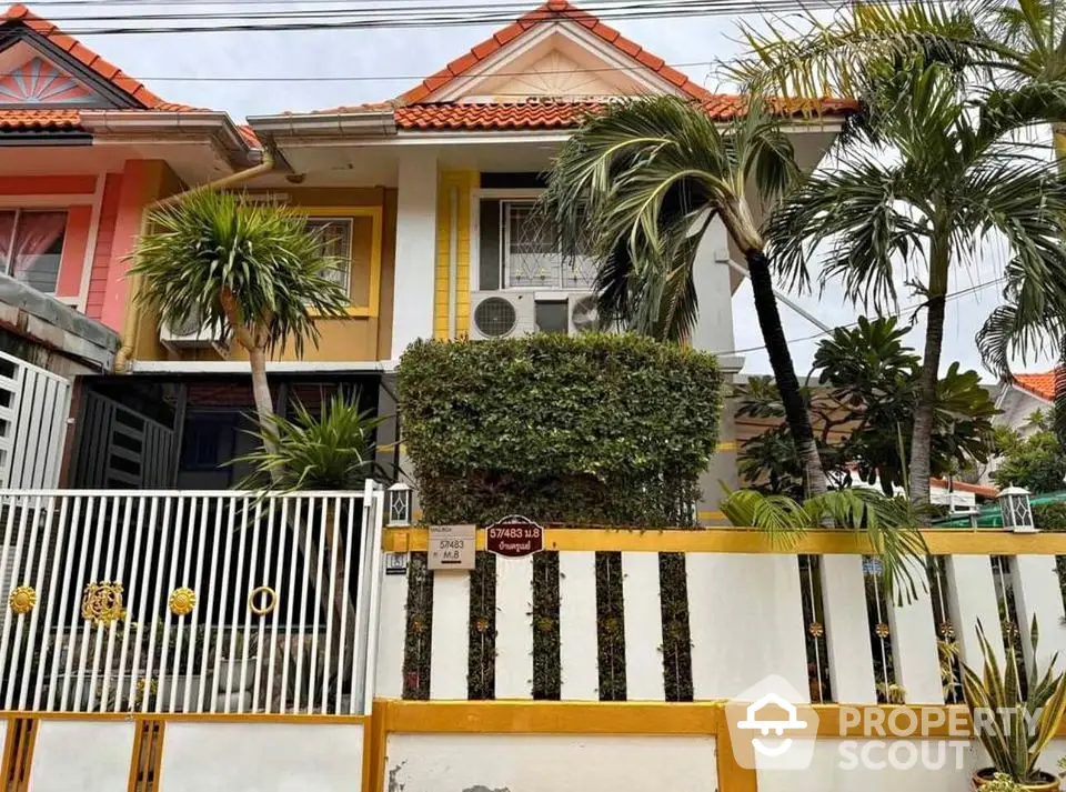 Charming townhouse with vibrant exterior and lush greenery in a serene neighborhood.