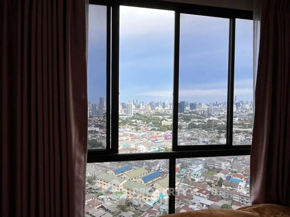 Stunning cityscape view from high-rise apartment window with elegant curtains framing the skyline.