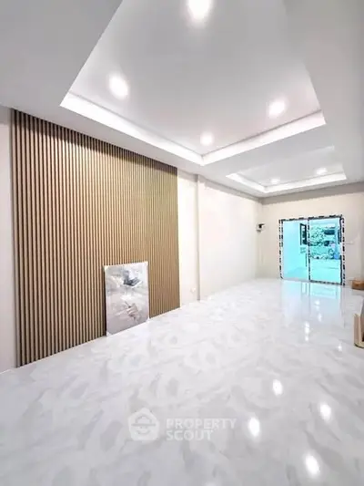 Spacious modern living room with elegant ceiling lights and marble flooring.