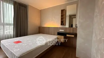 Modern bedroom with stylish decor and large window offering natural light.